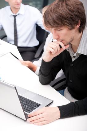 Friendly executive sitting in front of laptop